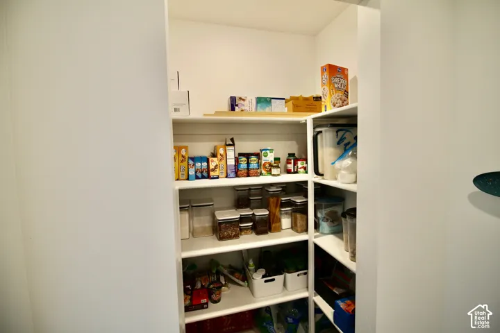 Corner pantry with multiple white built-in shelves