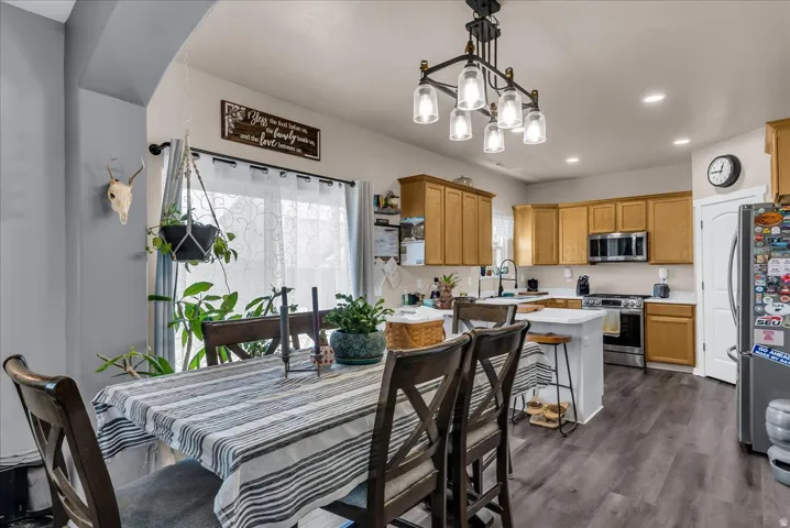Wood-finish flooring throughout, kitchen with wood cabinetry, stainless steel appliances, and a central island