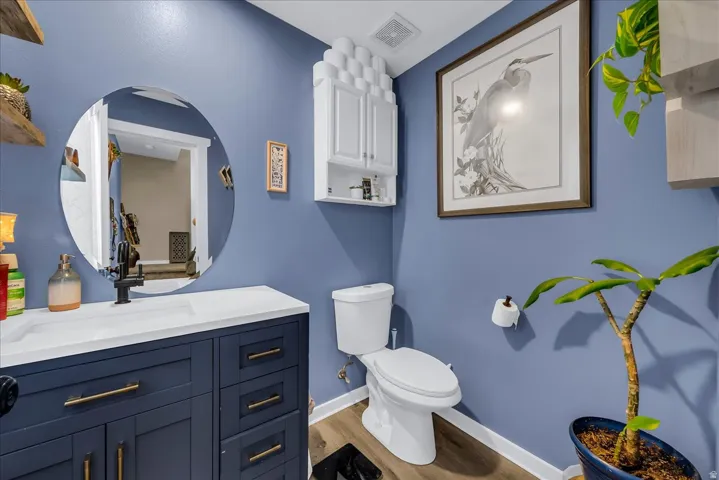 Navy blue vanity with gold-tone hardware, white countertop, and circular mirror
