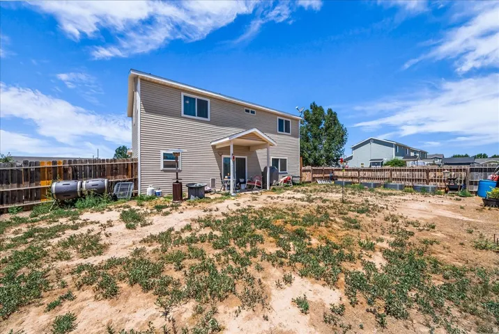 Two-story exterior with horizontal siding, covered patio, and fenced perimeter