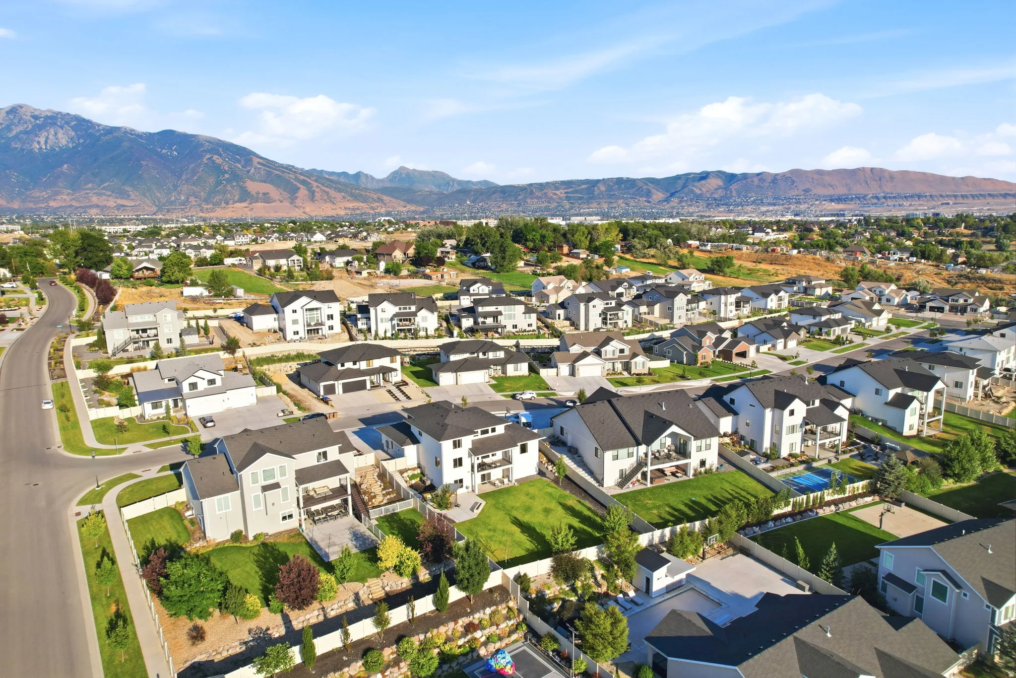 Aerial view of a modern residential community featuring contemporary homes with clean architectural lines, dark-toned roofing, and manicured landscaping throughout the development