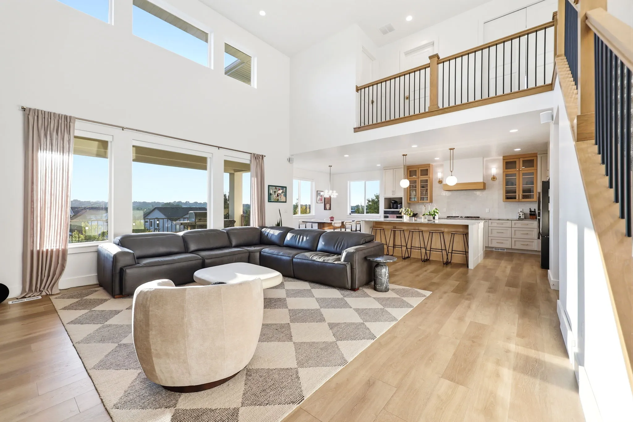 Open-concept living space featuring a two-story design with abundant natural light from expansive windows and clerestory glazing