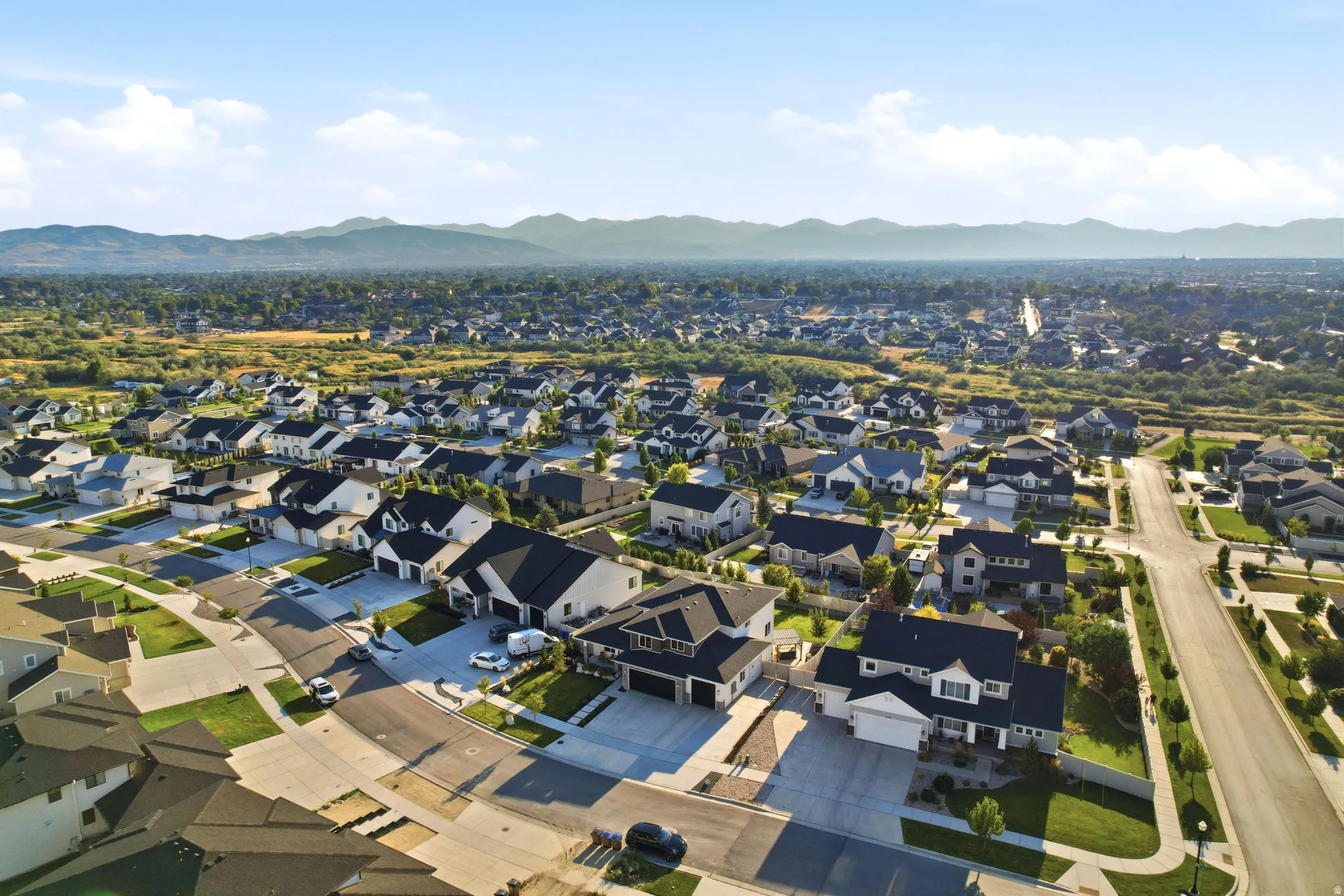 Aerial view of this established residential community showcasing a collection of newly constructed homes with modern architectural styling, manicured landscaping, and paved driveways