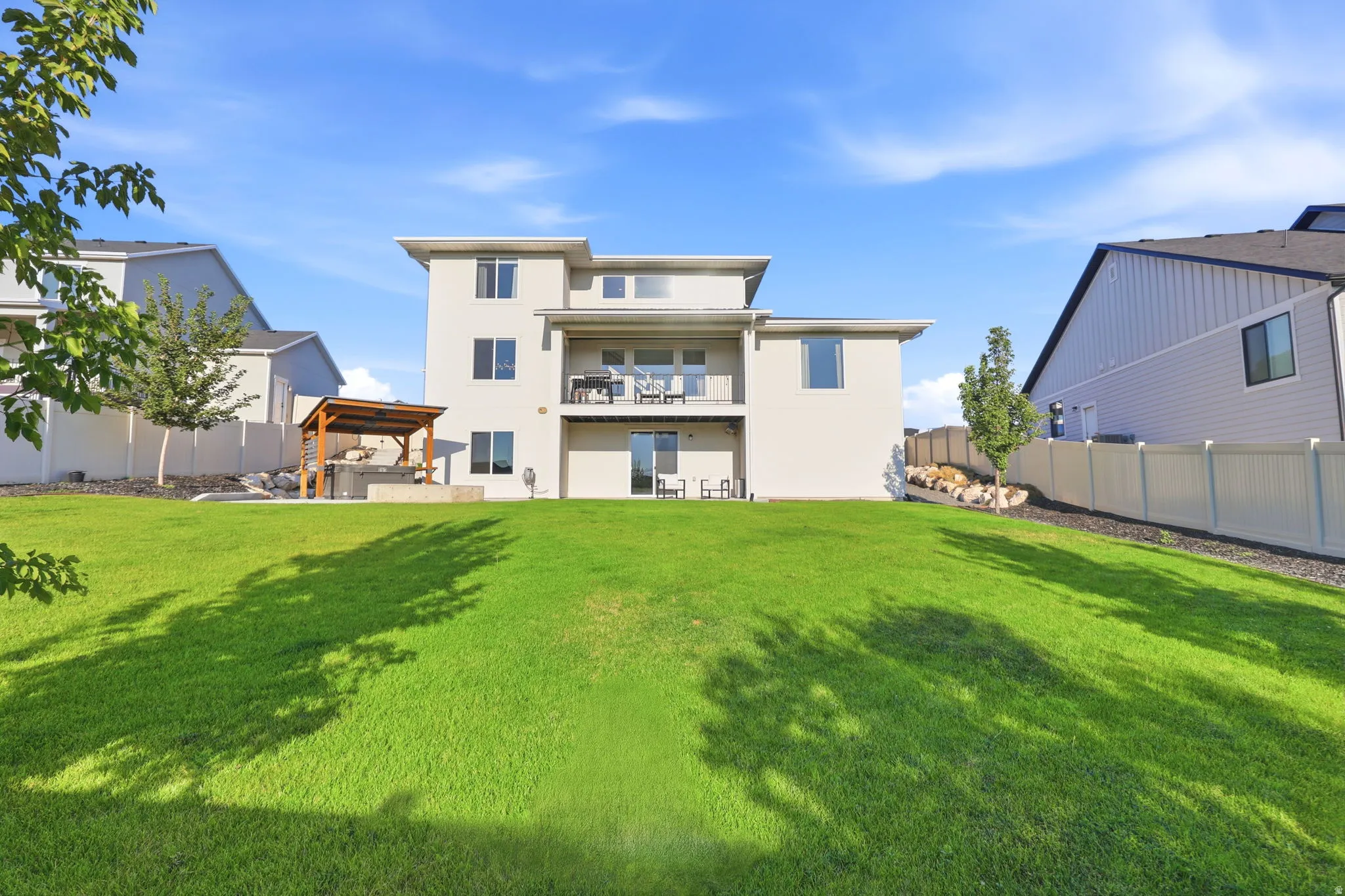 Expansive green lawn with a modern stucco exterior