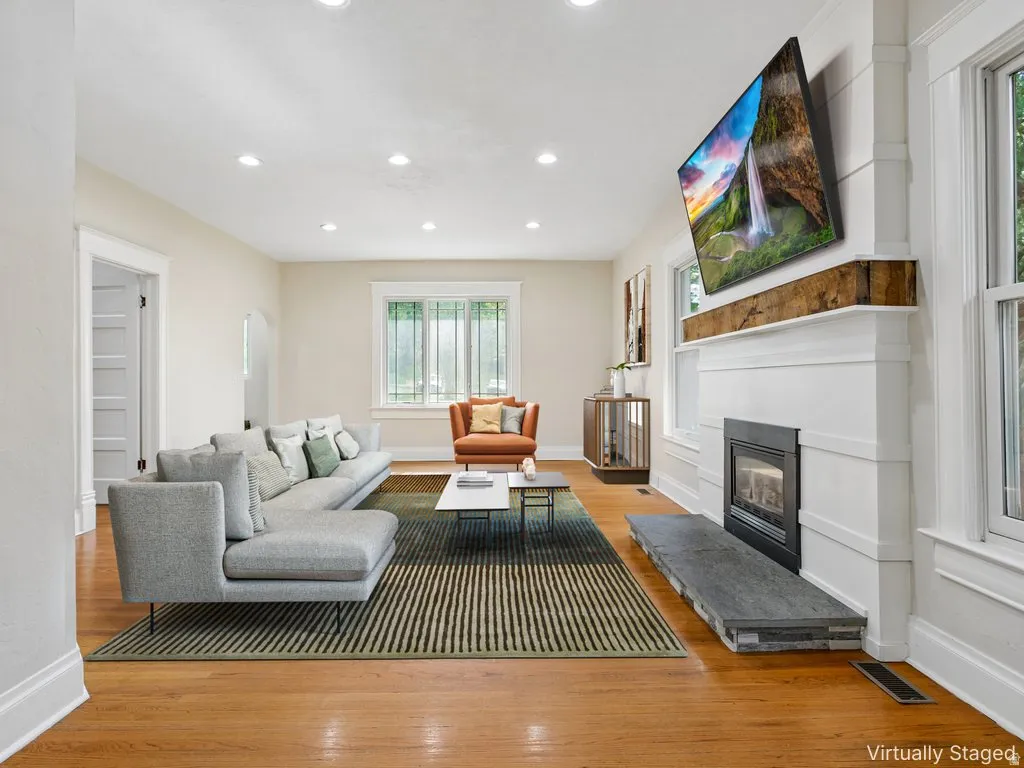 Living area featuring wood-finish flooring, recessed lighting, and white baseboards
