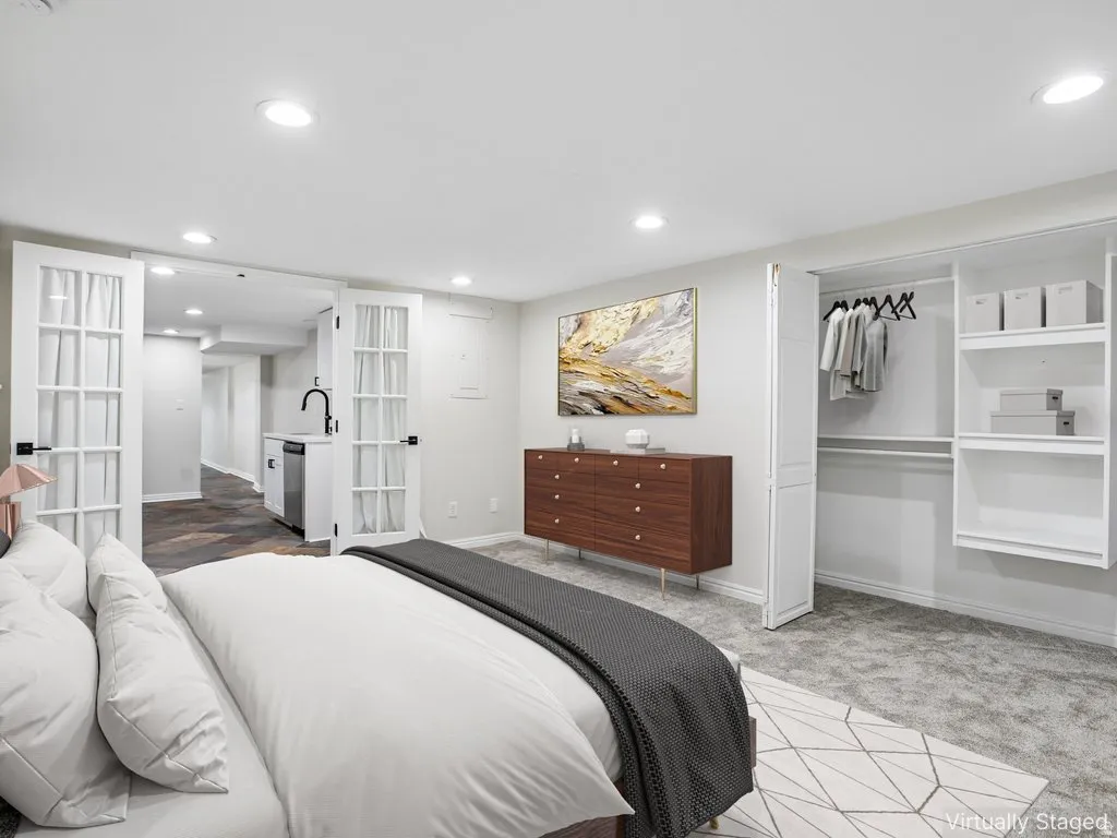 Spacious room featuring light gray walls, recessed lighting, and gray patterned carpet