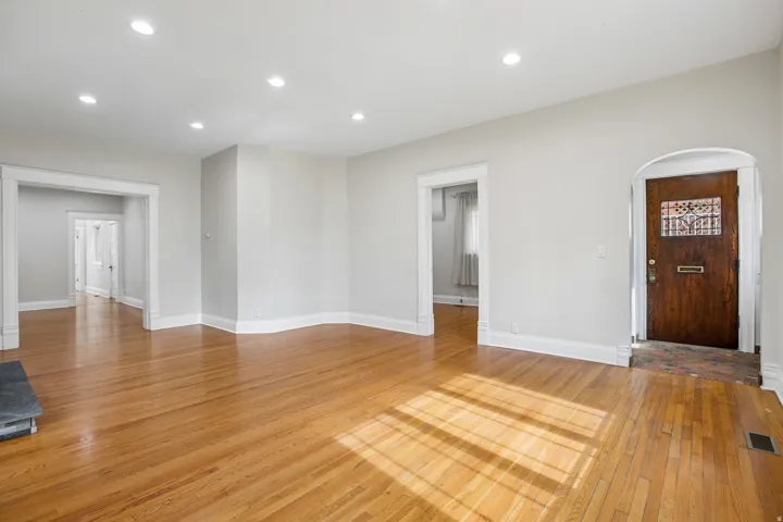 Spacious interior featuring hardwood flooring, recessed lighting, white trim, and light gray wall paint