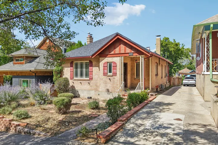 Brick exterior with a gabled entry and red decorative shutters