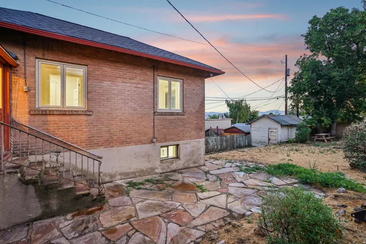 Brick exterior featuring multiple windows and a flagstone patio