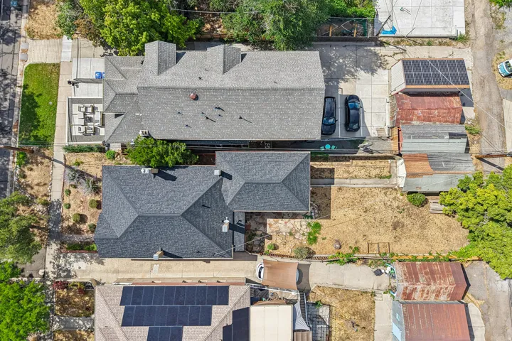 Two distinct residential structures with dark shingle roofing