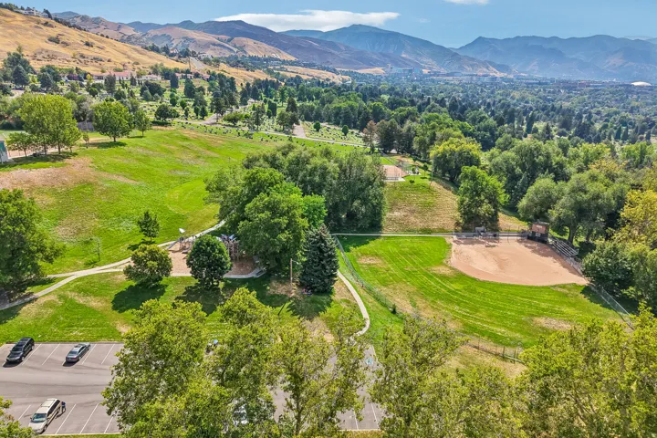 Expansive green spaces featuring a baseball field, playground, and mature trees