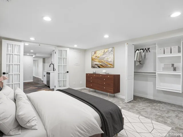 Spacious room featuring light gray walls, recessed lighting, and gray patterned carpet