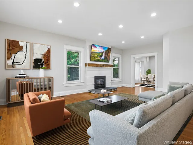 Living area featuring hardwood flooring and a fireplace with a wood mantel