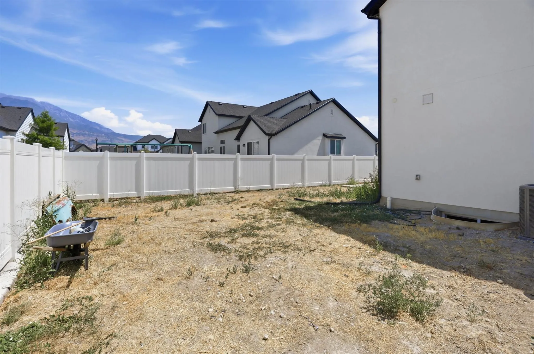 Spacious backyard lot with newly installed white vinyl fencing, level grading, and mountain vistas in the distance