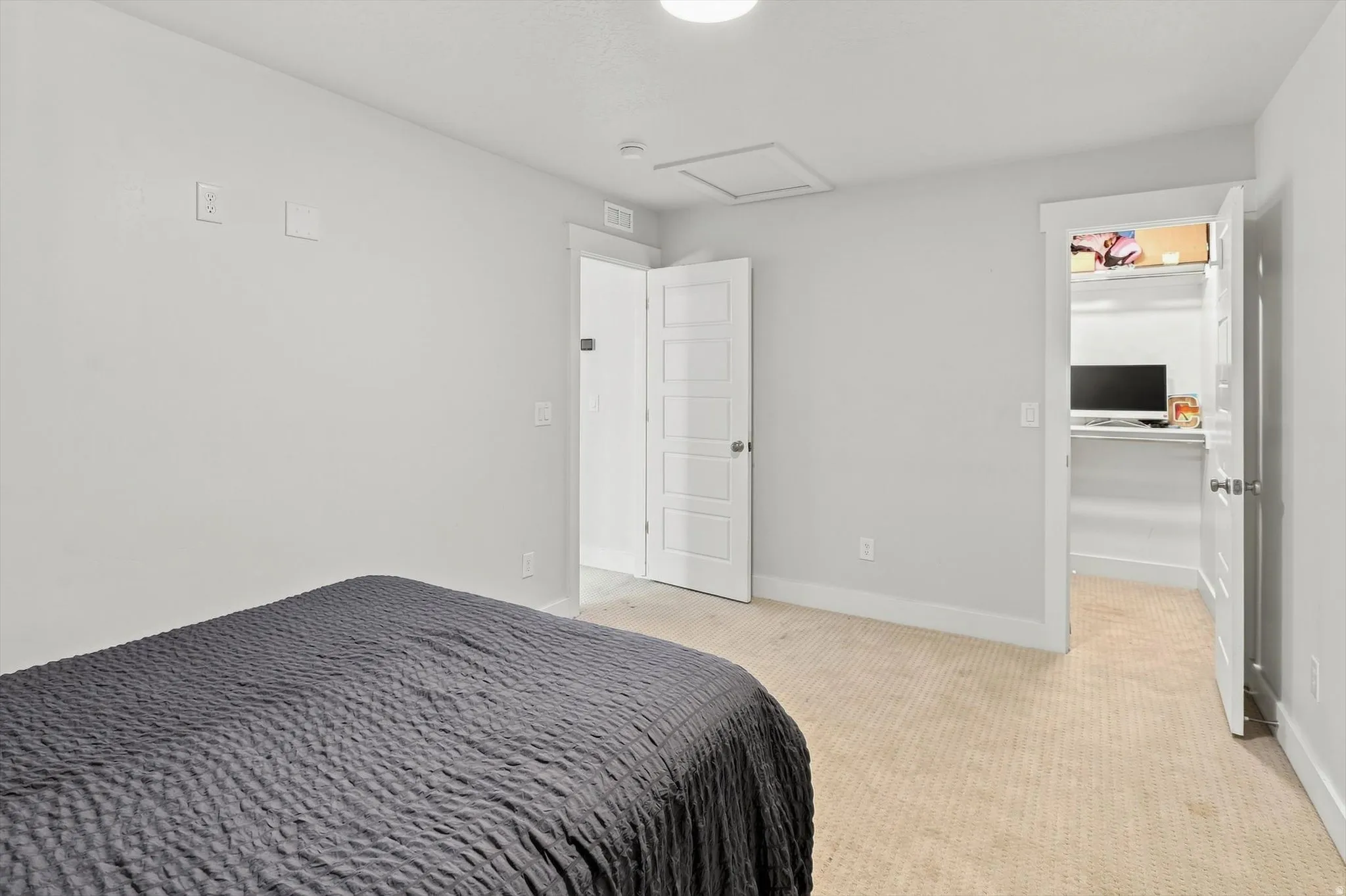 Spacious bedroom featuring neutral walls, wood-finish flooring, and abundant natural light
