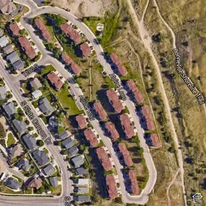 Aerial Map. Showing a residential development with individual structures and connecting roadways, bordered by a trail system