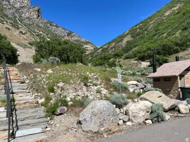 Scenic canyon-view setting with native desert landscaping, mature shrubs, and natural stone hardscaping