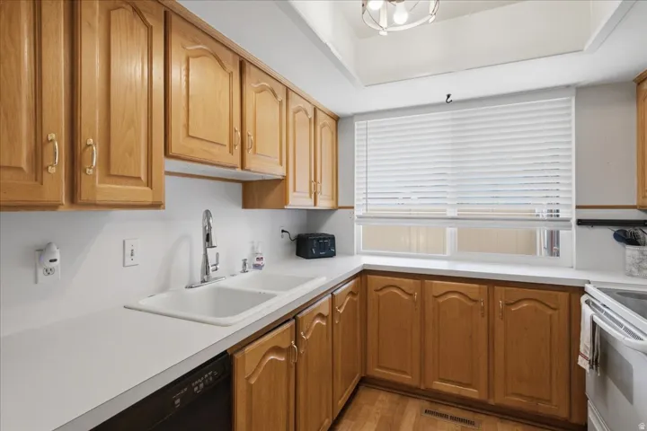 Kitchen featuring a double basin sink with a chrome faucet and a built-in dishwasher