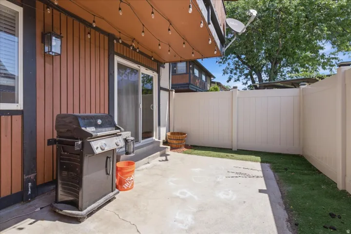 Outdoor patio space featuring a concrete slab and artificial turf