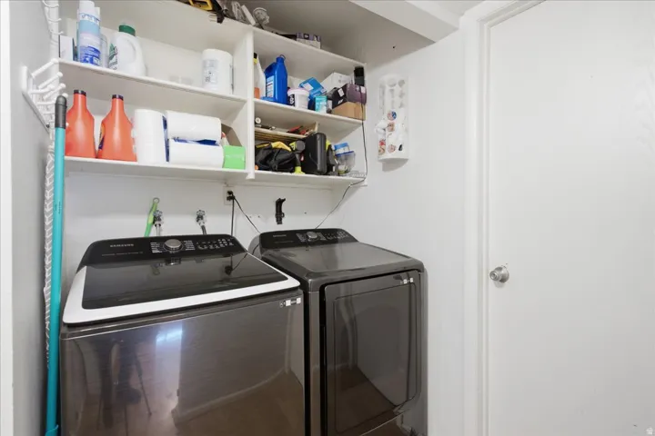 Dedicated laundry area featuring a white door, white walls, and built-in shelving