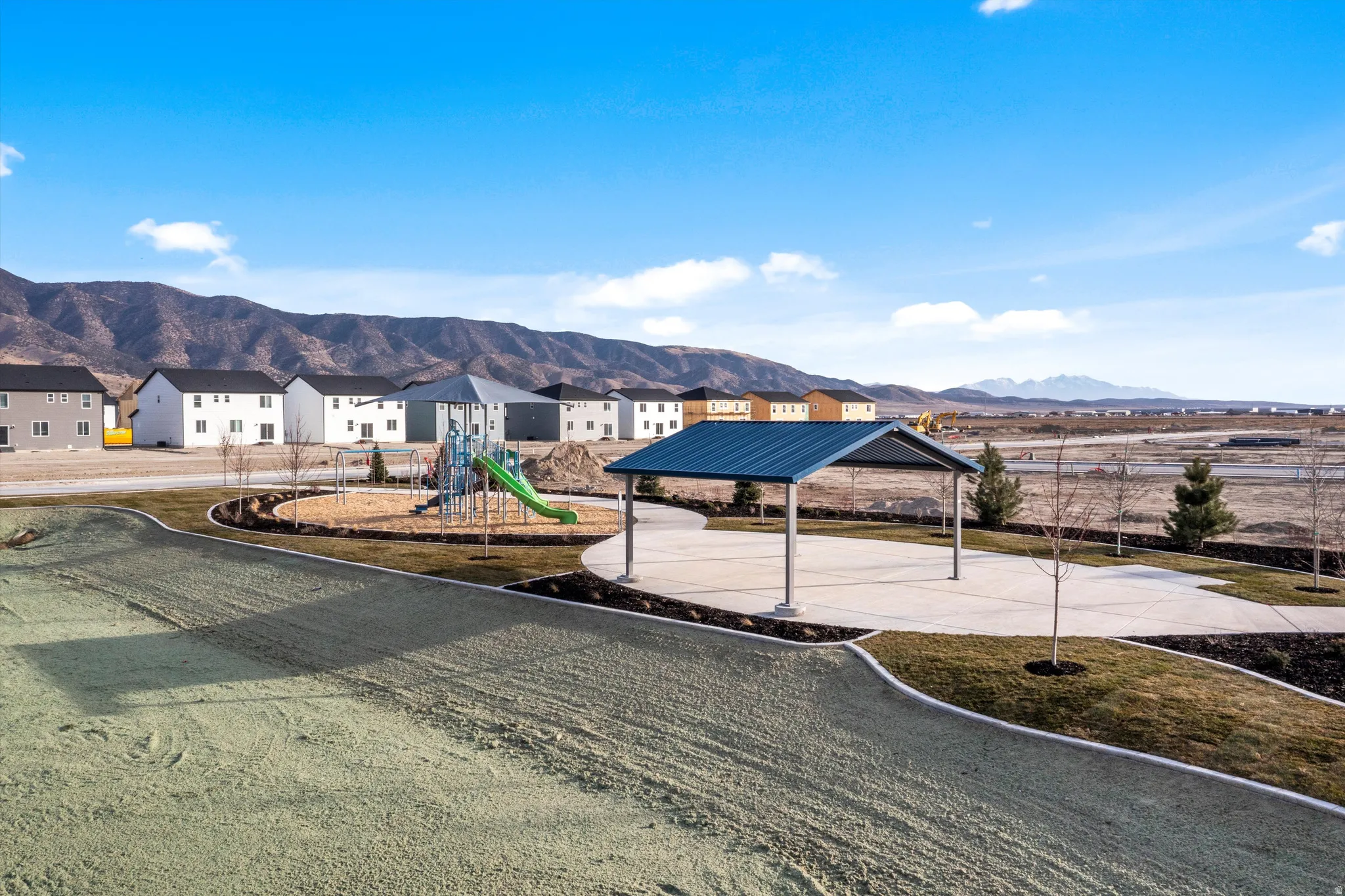 Community playground with a slide, covered picnic area, and surrounding residential structures