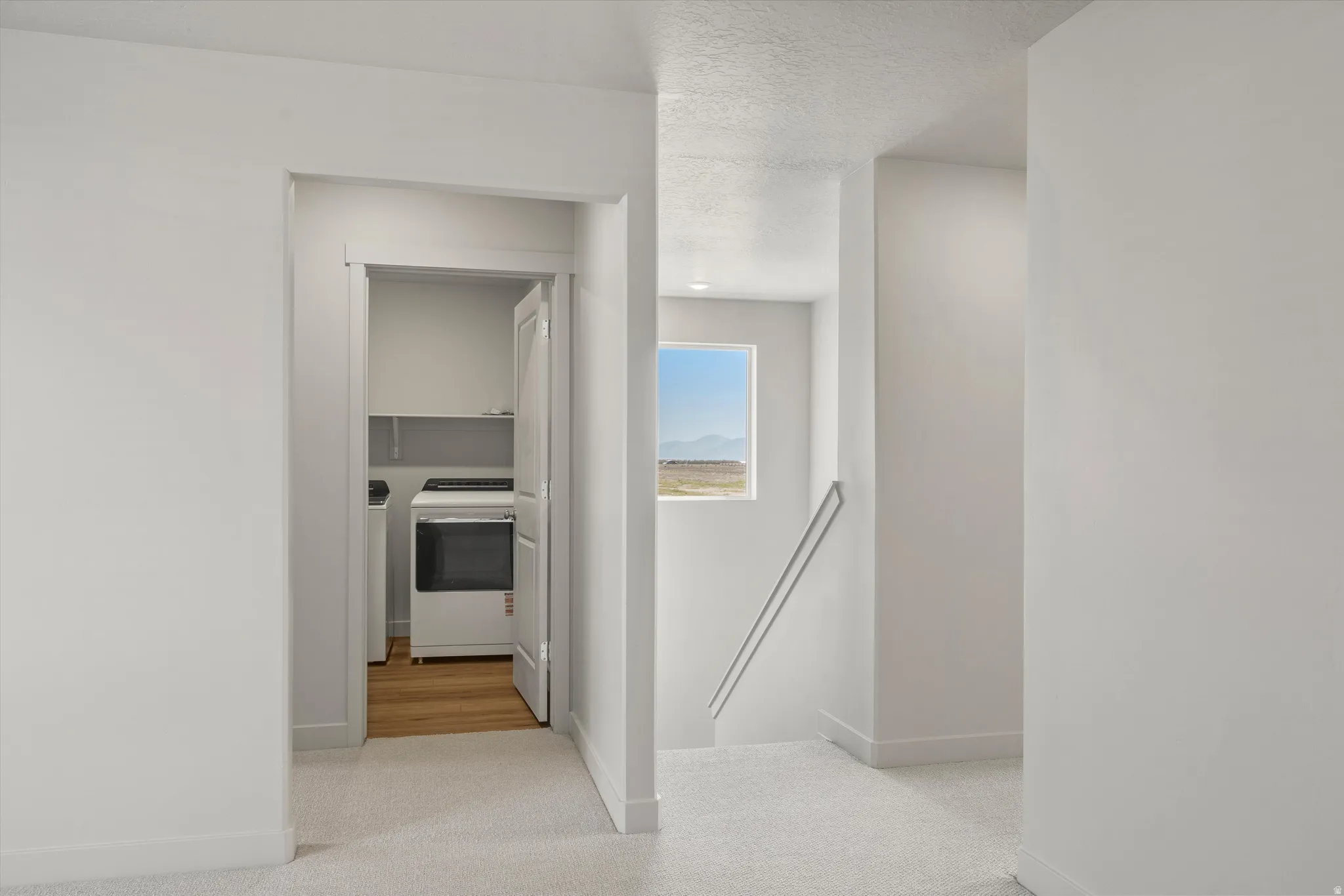 **DISCLAIMER** Interior package may vary. Laundry area with shelving and wood-finish flooring