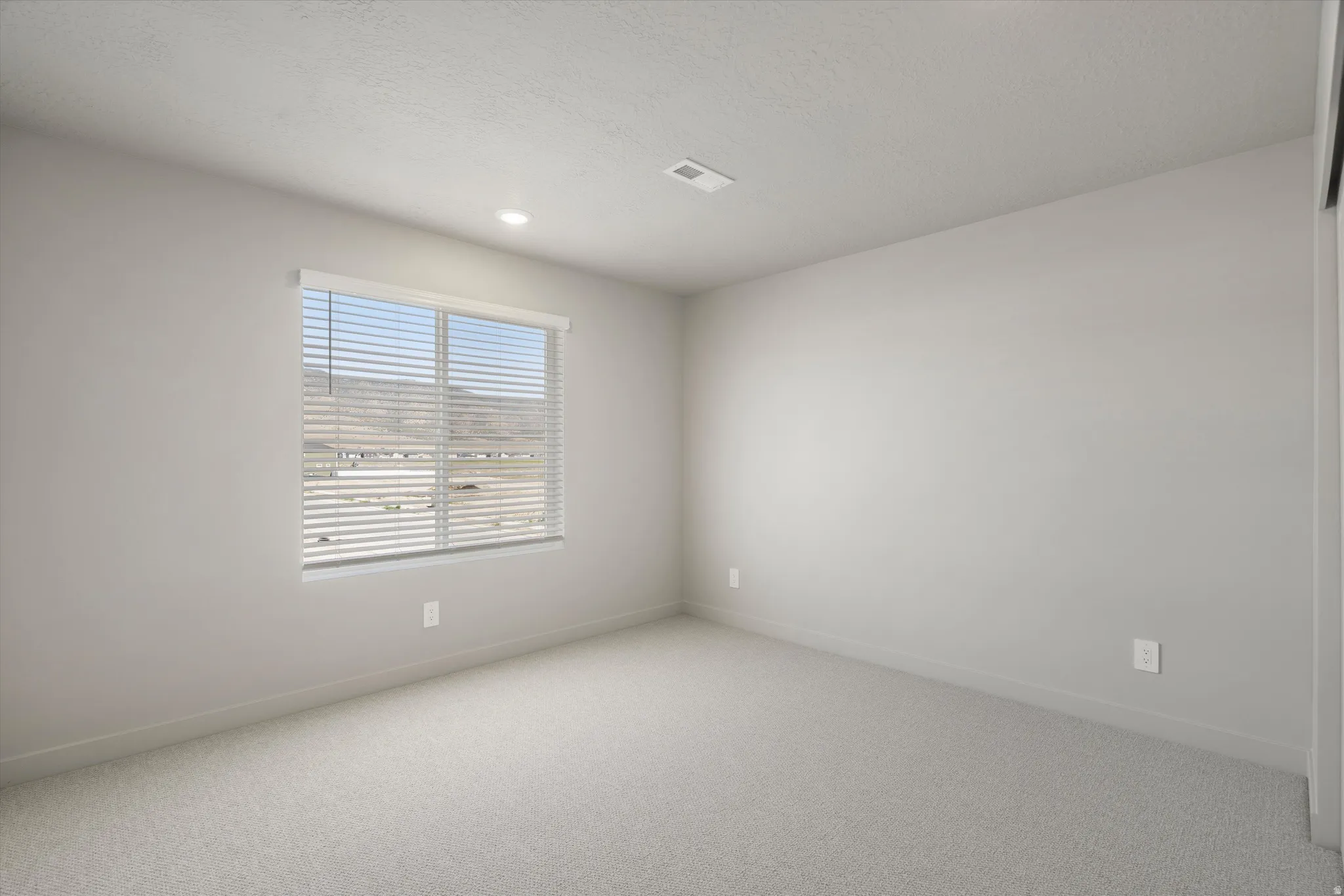**DISCLAIMER** Interior package may vary. Recessed lighting with a large window, neutral wall tones, and carpet flooring