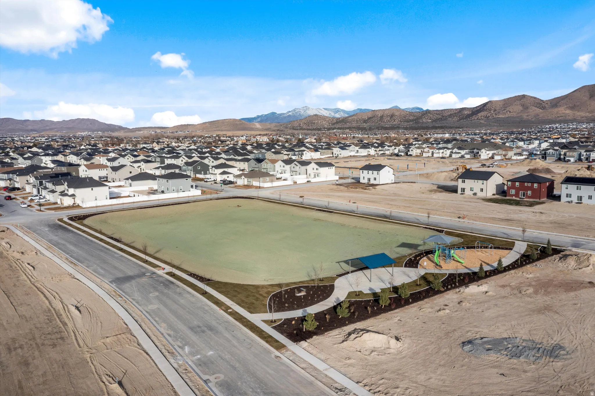 Expansive green space and a dedicated recreational area with shade structures and play equipment