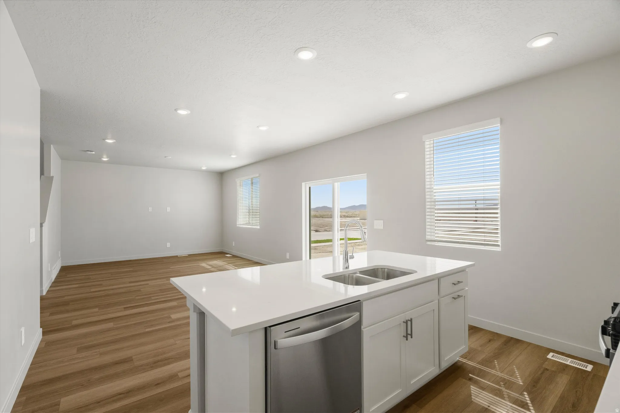 **DISCLAIMER** Interior package may vary. Kitchen island with white countertops and an integrated double basin sink