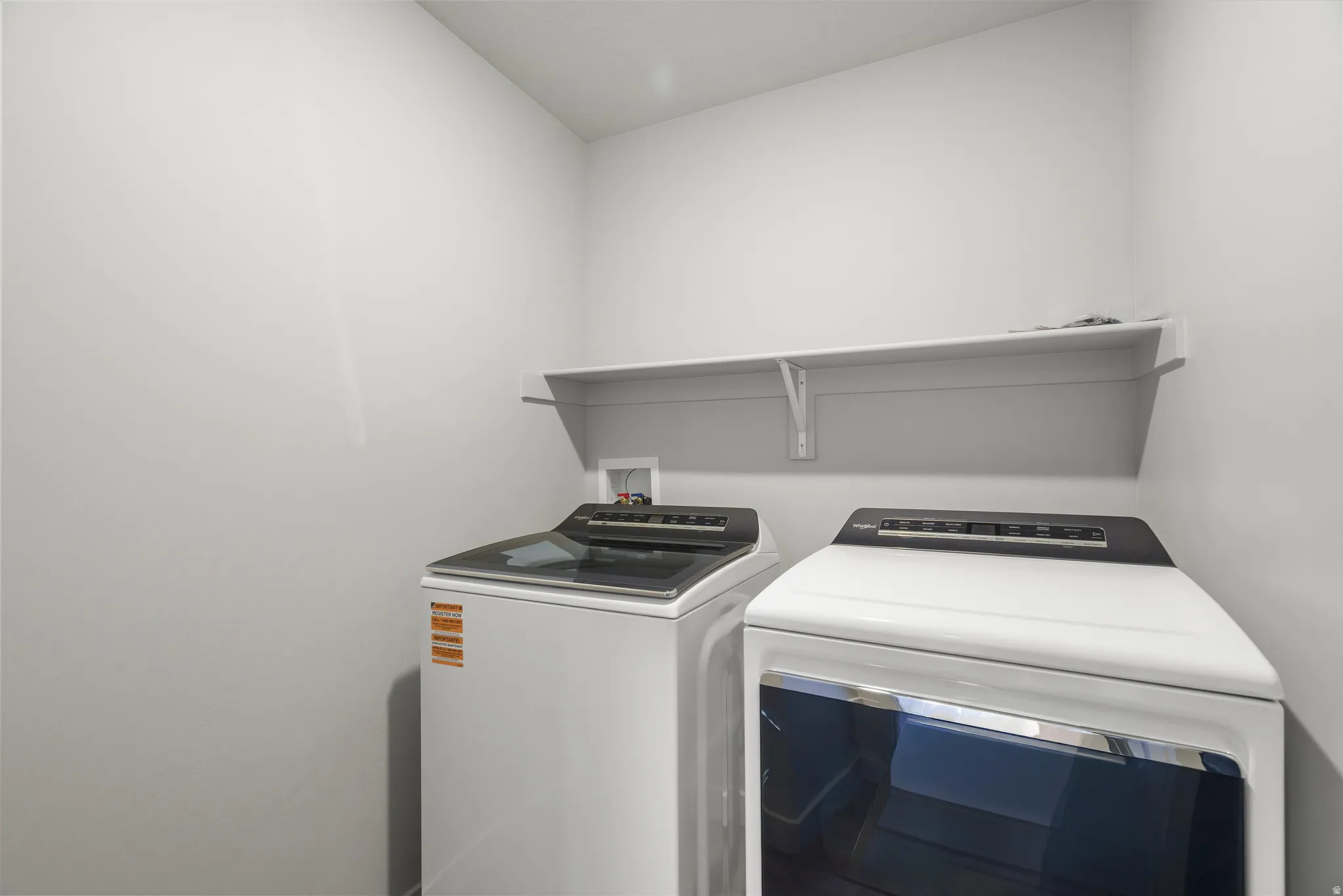 **DISCLAIMER** Interior package may vary. Laundry area with white walls and an upper storage shelf