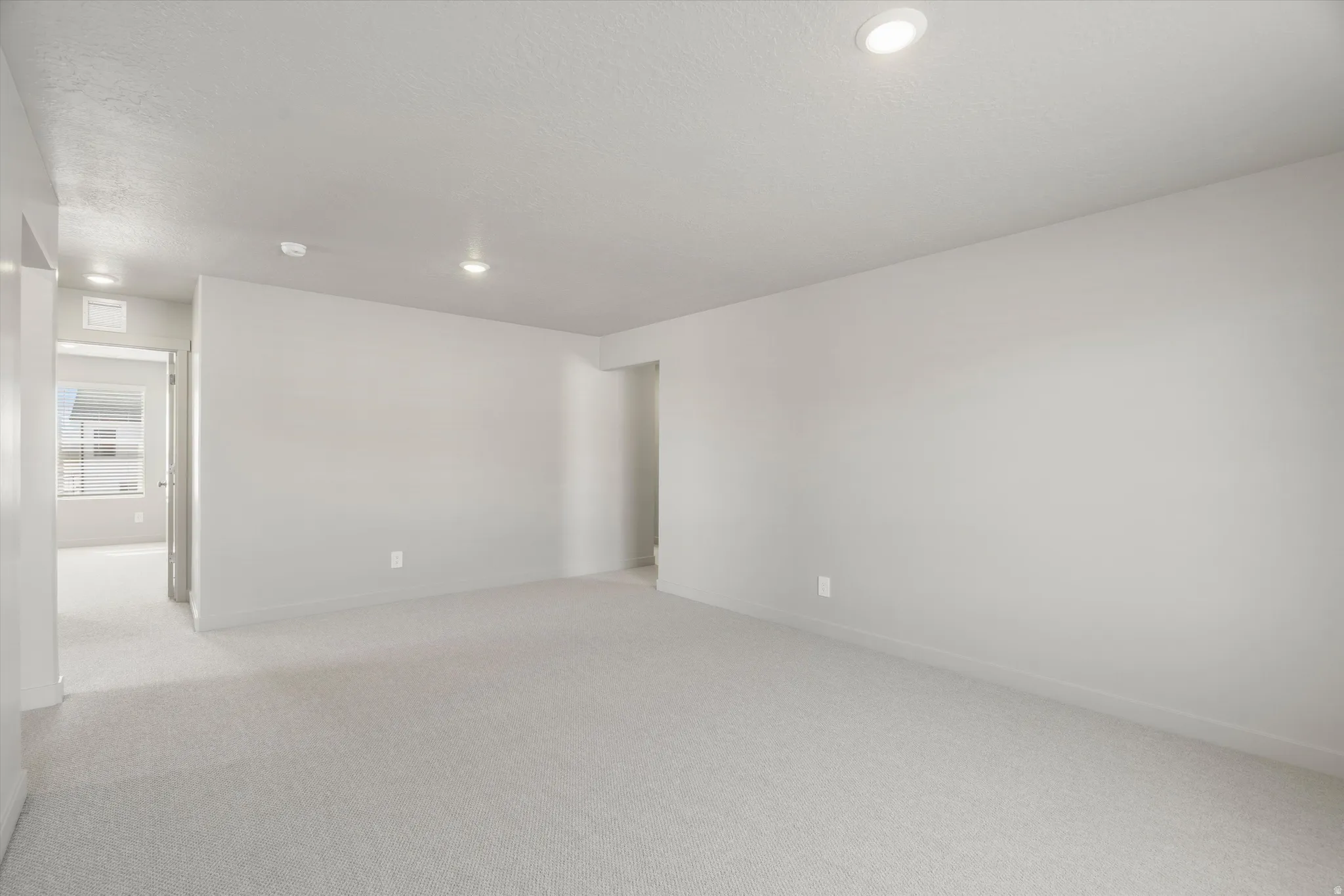 **DISCLAIMER** Interior package may vary. Recessed lighting, light gray carpet, and crisp white walls create an open atmosphere
