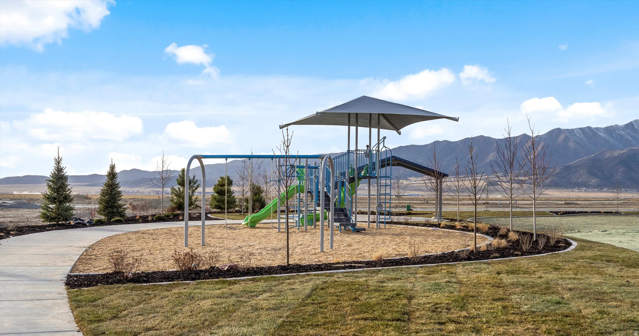 Community playground featuring a shade structure and swings