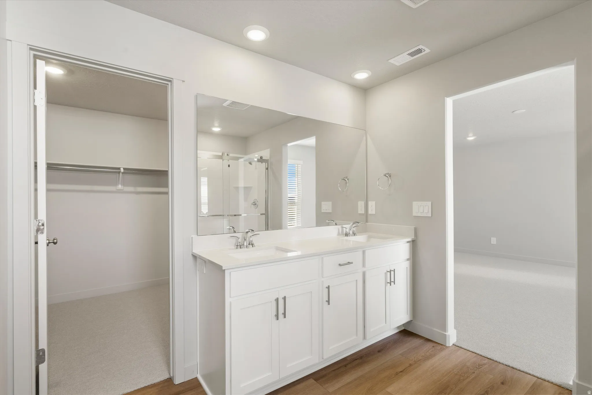 **DISCLAIMER** Interior package may vary. Bathroom featuring a dual vanity with white cabinetry, a light-colored countertop, and two undermount sinks