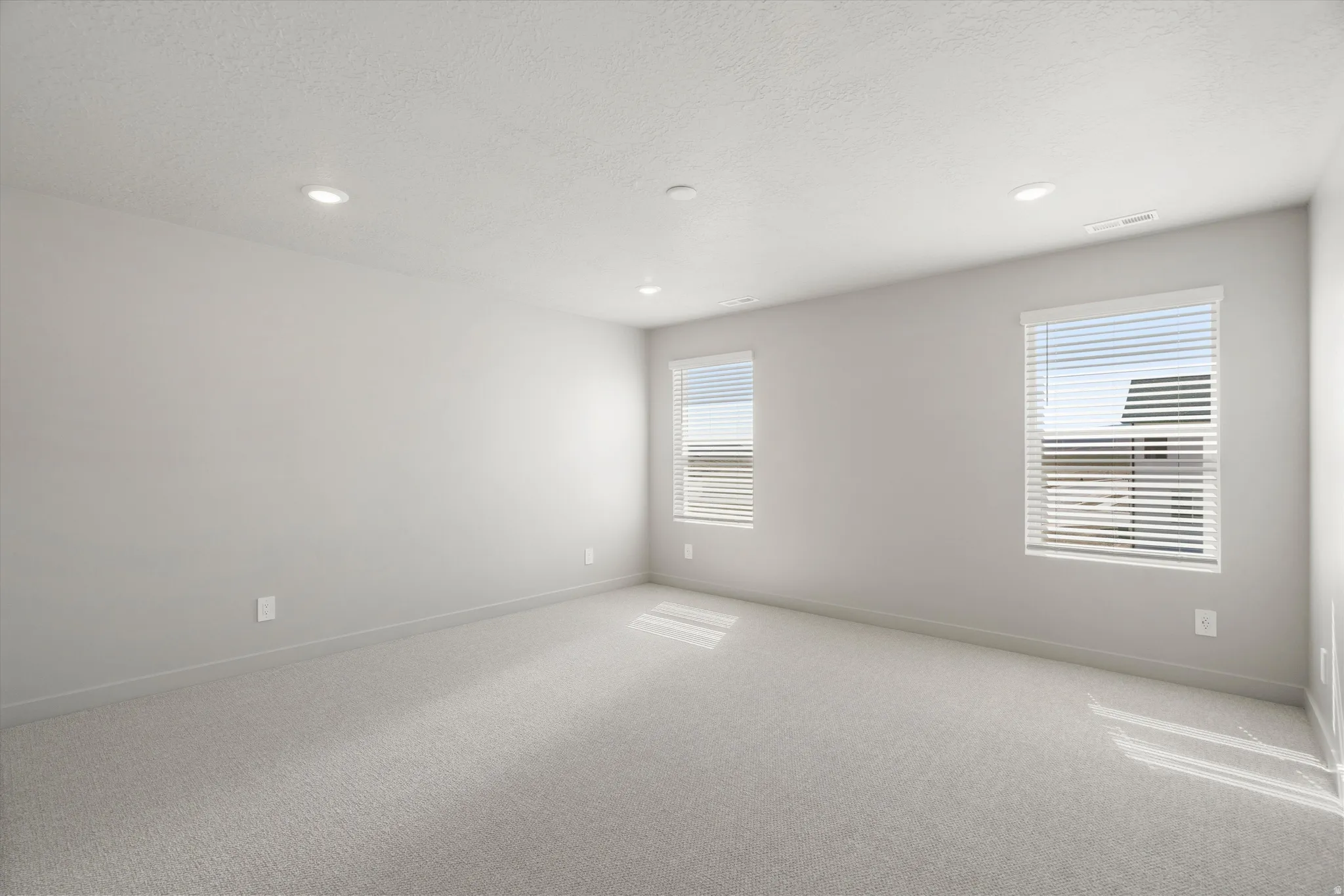 **DISCLAIMER** Interior package may vary. Neutral tone walls, recessed lighting, two windows with blinds, and light-toned carpeting