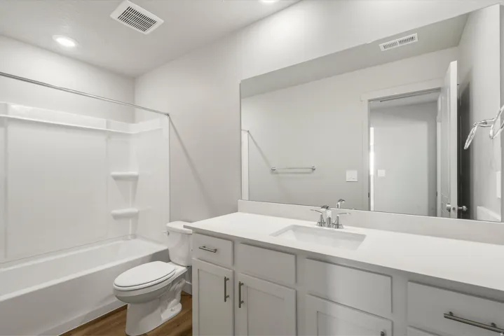 **DISCLAIMER** Interior package may vary. Bathroom with a white vanity featuring a rectangular under-mount sink, chrome faucet, and expansive mirror