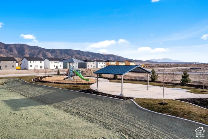 Community playground with a slide, covered picnic area, and surrounding residential structures