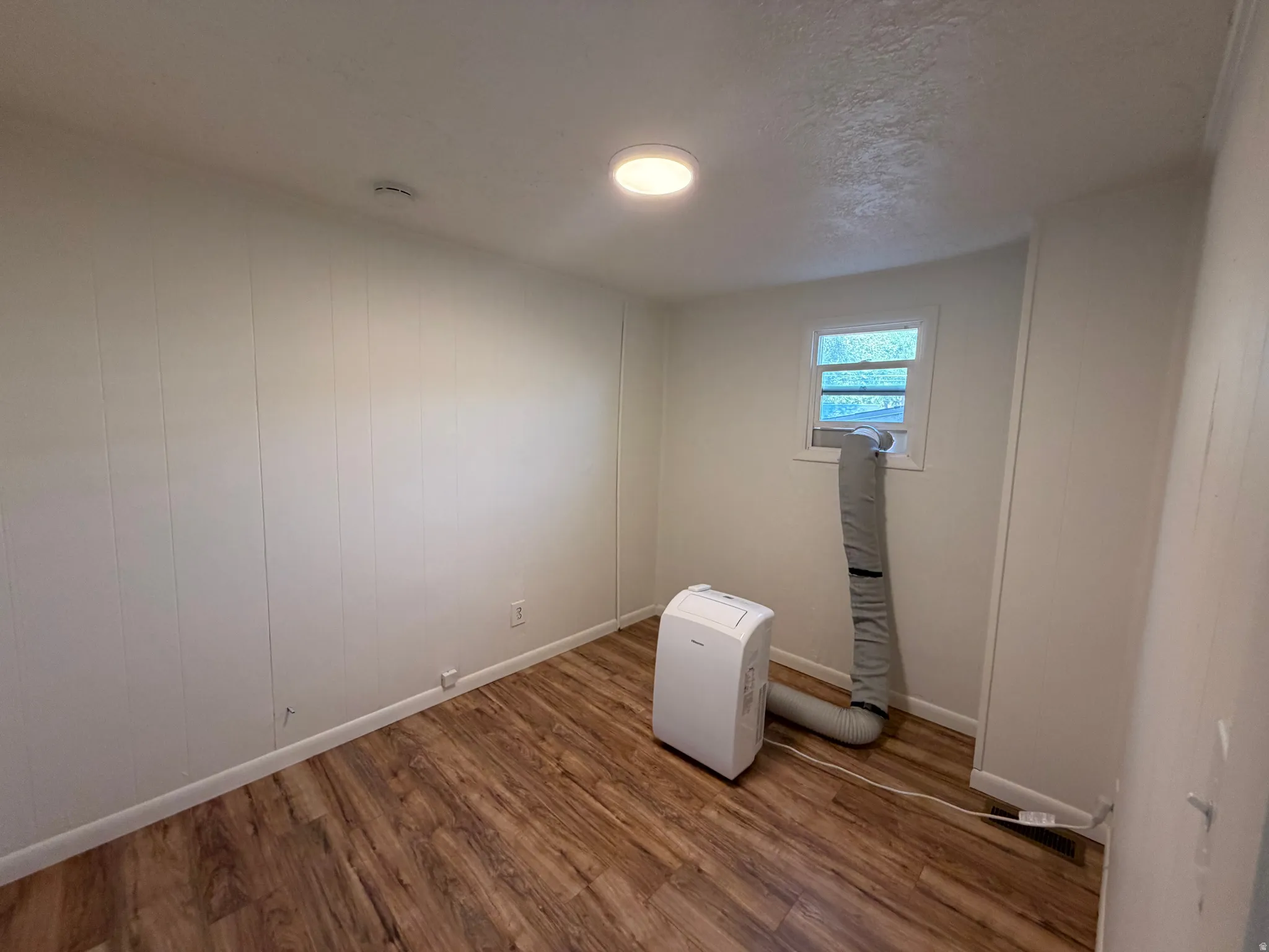 Wood-finish flooring with white wall paneling