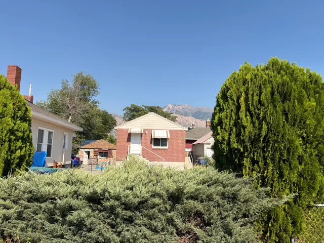 Brick exterior with white door, awning, and mountain backdrop