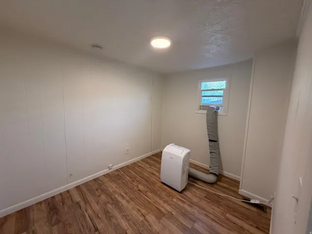 Wood-finish flooring with white wall paneling