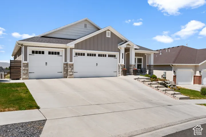 Contemporary ranch-style residence featuring a three-car garage with carriage-style doors