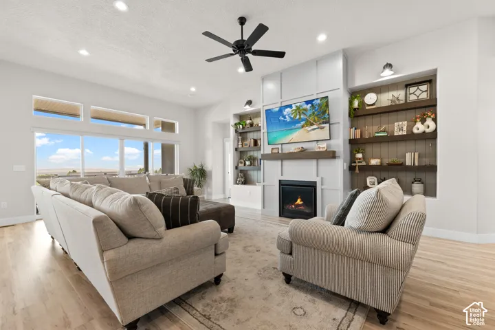 Living area featuring a gas fireplace with a wood mantle and built-in shelving
