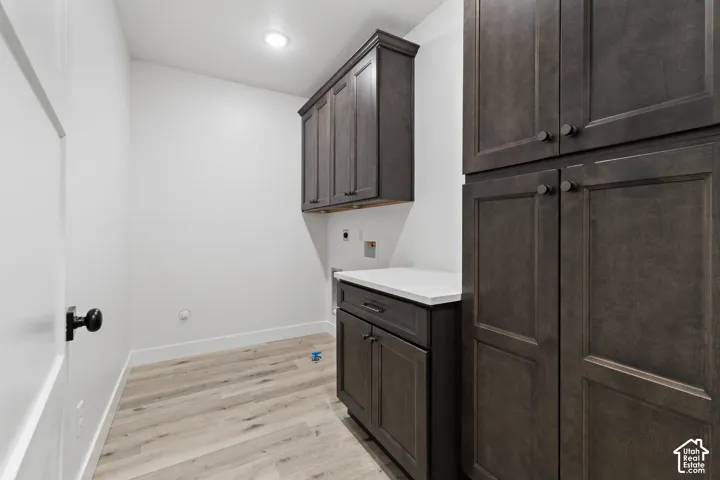 Utility room featuring wood-finish flooring, white walls, and recessed lighting