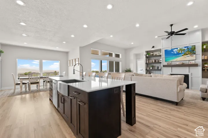 Spacious kitchen island with a farmhouse sink and dark wood cabinetry