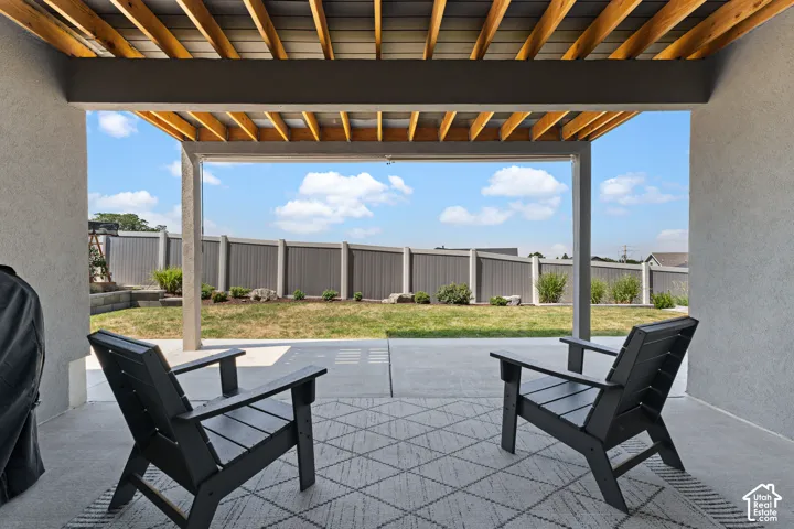 Covered patio with a slatted wood ceiling and concrete flooring