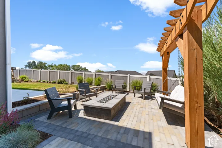 Sophisticated outdoor living space featuring a linear fire table, multiple Adirondack seating areas, and composite paver patio
