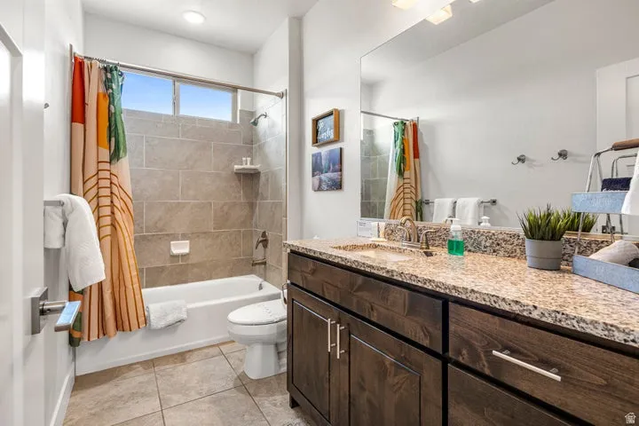 Spa-inspired master bathroom featuring a wood-finish vanity with dual sinks, granite countertop, and polished chrome hardware