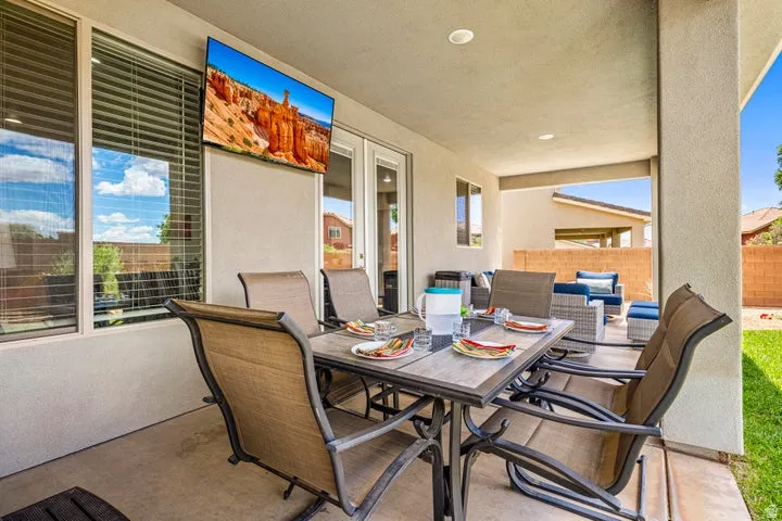Covered patio with recessed lighting, concrete flooring, and an exterior mounted television