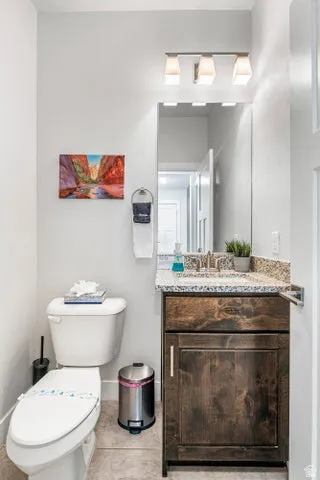 Spa-inspired powder room featuring a wood-finish vanity with granite countertop, vessel sink, and brushed nickel fixtures