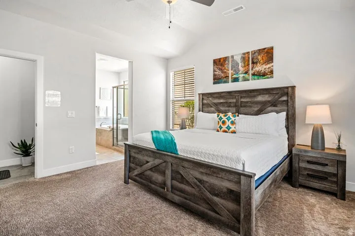 Carpeted bedroom with vaulted ceiling and ceiling fan