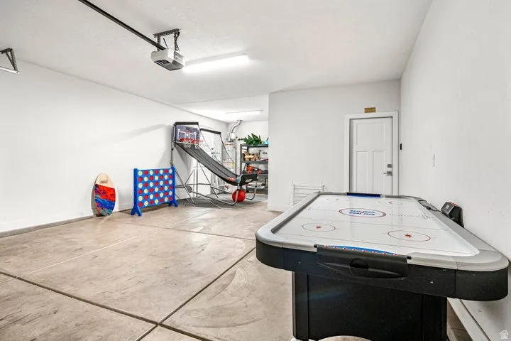 Finished Basement Recreation Space featuring concrete flooring, ceiling-mounted lighting, and built-in air hockey table